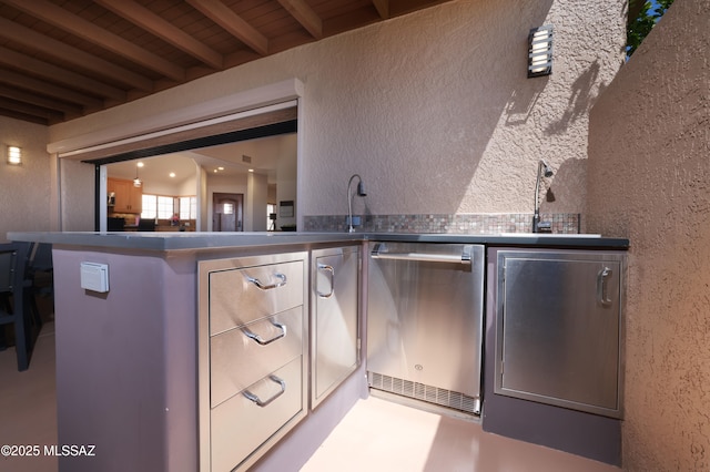 bar featuring dishwasher, wooden ceiling, a textured wall, and beamed ceiling