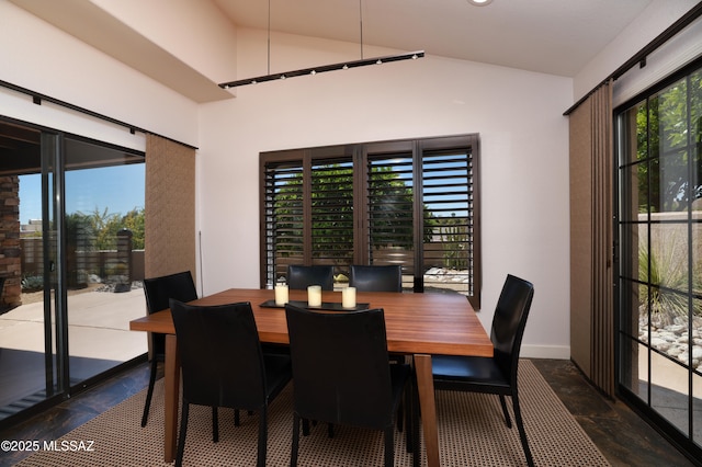 dining area with vaulted ceiling and baseboards