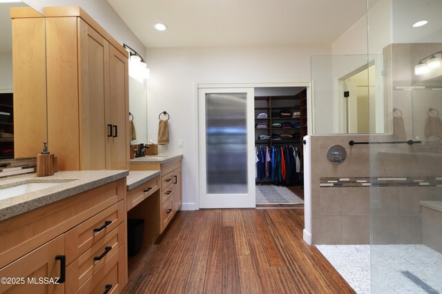 full bathroom with recessed lighting, a spacious closet, wood finished floors, vanity, and a walk in shower