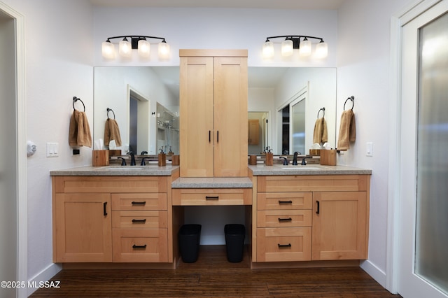full bathroom featuring baseboards, wood finished floors, vanity, and a shower with door