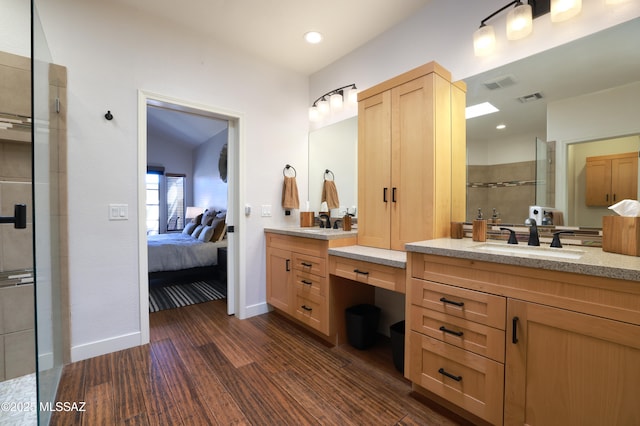 ensuite bathroom featuring a shower stall, wood finished floors, a sink, and visible vents