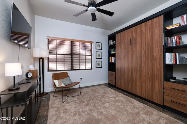 sitting room with baseboards and ceiling fan