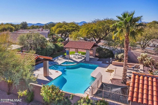 outdoor pool with a gazebo, a fenced backyard, a mountain view, a patio, and an in ground hot tub