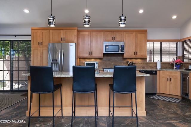 kitchen with a center island, beverage cooler, appliances with stainless steel finishes, and a healthy amount of sunlight