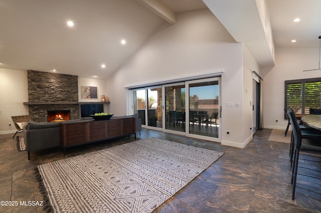 living room with a fireplace, stone tile floors, high vaulted ceiling, and recessed lighting