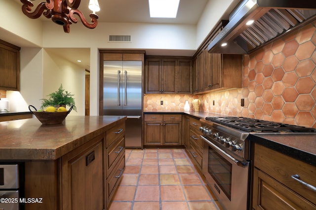 4915 N Via De La Granja, Tucson, AZ 85718 - kitchen featuring high end appliances, wall chimney range hood, dark countertops, and recessed lighting