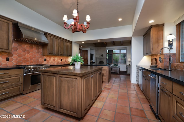 4915 N Via De La Granja, Tucson, AZ 85718 - kitchen with stainless steel appliances, wall chimney exhaust hood, a sink, a kitchen island, and a chandelier