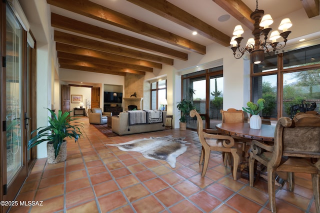 4915 N Via De La Granja, Tucson, AZ 85718 - dining space with beamed ceiling, a chandelier, a large fireplace, and tile patterned flooring