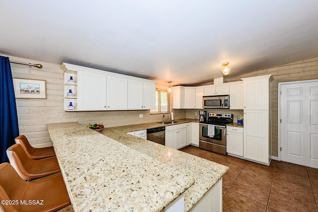 1652 W Roller Coaster Rd, Tucson, AZ 85704 - kitchen with a sink, dark tile patterned flooring, stainless steel appliances, a peninsula, and white cabinetry