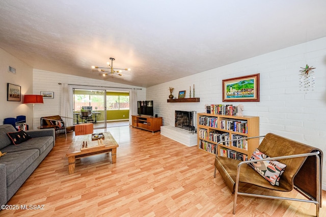 1652 W Roller Coaster Rd, Tucson, AZ 85704 - living area with an inviting chandelier, vaulted ceiling, visible vents, light wood-style floors, and a fireplace