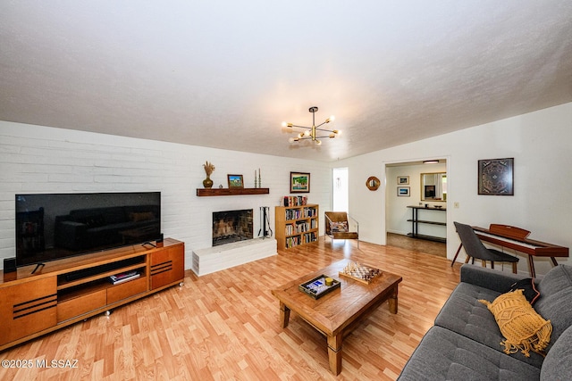 1652 W Roller Coaster Rd, Tucson, AZ 85704 - living room with wood finished floors, a brick fireplace, and an inviting chandelier