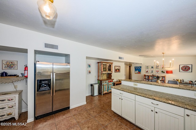 1652 W Roller Coaster Rd, Tucson, AZ 85704 - kitchen with visible vents, a notable chandelier, white cabinetry, tile patterned flooring, and stainless steel fridge with ice dispenser
