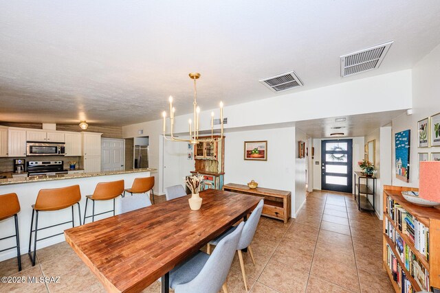 1652 W Roller Coaster Rd, Tucson, AZ 85704 - dining space featuring light tile patterned flooring, visible vents, and an inviting chandelier