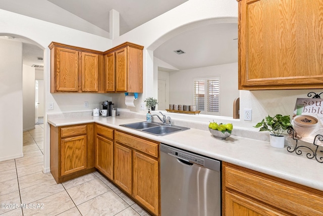 kitchen with vaulted ceiling, a sink, arched walkways, and dishwasher