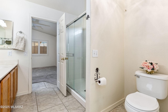 bathroom with toilet, vanity, vaulted ceiling, a shower stall, and baseboards