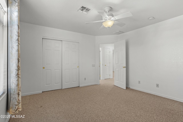 unfurnished bedroom featuring a closet, baseboards, carpet flooring, visible vents, and ceiling fan