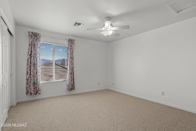spare room featuring visible vents, light colored carpet, baseboards, and ceiling fan