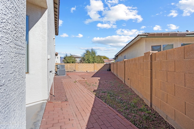 view of property exterior featuring a fenced backyard, central air condition unit, and stucco siding