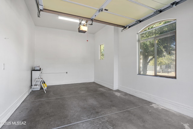 garage featuring a garage door opener and baseboards