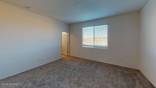 carpeted spare room with baseboards