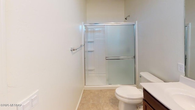 bathroom with vanity, baseboards, tile patterned flooring, toilet, and a shower with shower door