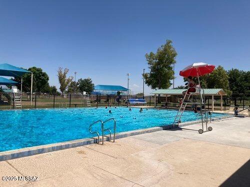 pool with a patio area and fence