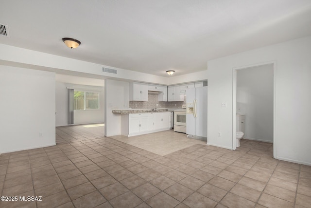 kitchen with visible vents, white appliances, open floor plan, light countertops, and white cabinets