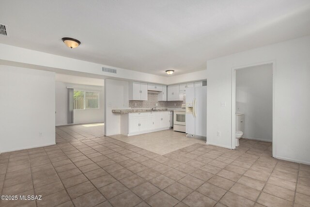 kitchen with visible vents, white appliances, open floor plan, light countertops, and white cabinets