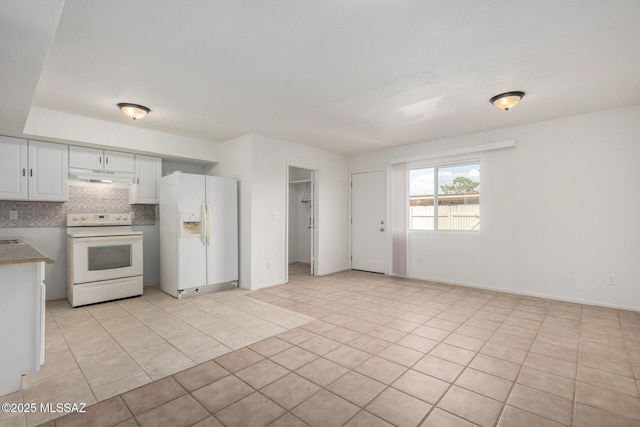 kitchen with backsplash, light tile patterned floors, white cabinets, under cabinet range hood, and white appliances