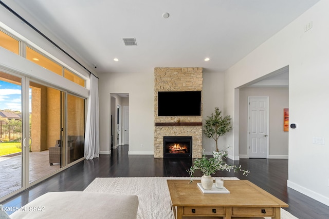 living room with recessed lighting, wood finished floors, visible vents, a stone fireplace, and baseboards