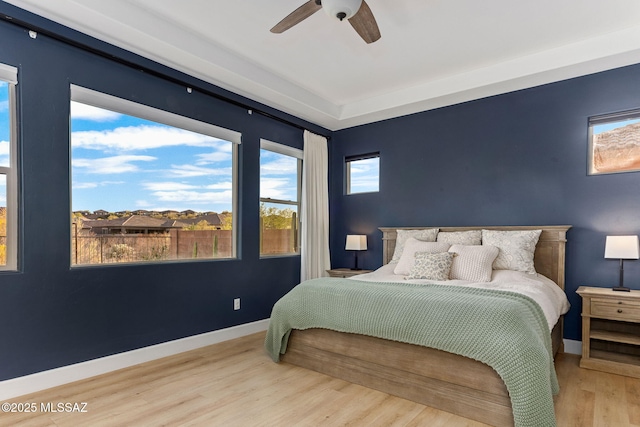 bedroom with baseboards, a ceiling fan, and wood finished floors