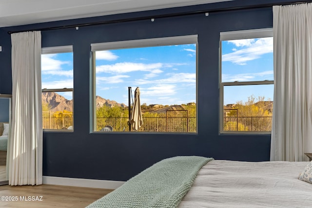 bedroom with baseboards and wood finished floors