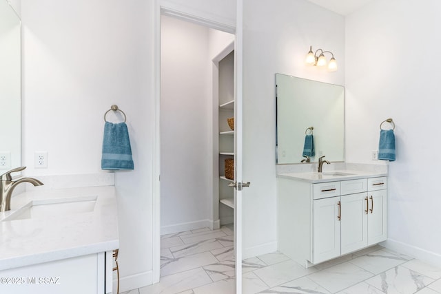 bathroom featuring two vanities, marble finish floor, and a sink