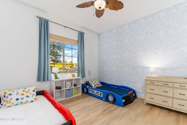 bedroom featuring wallpapered walls, wood finished floors, and ceiling fan