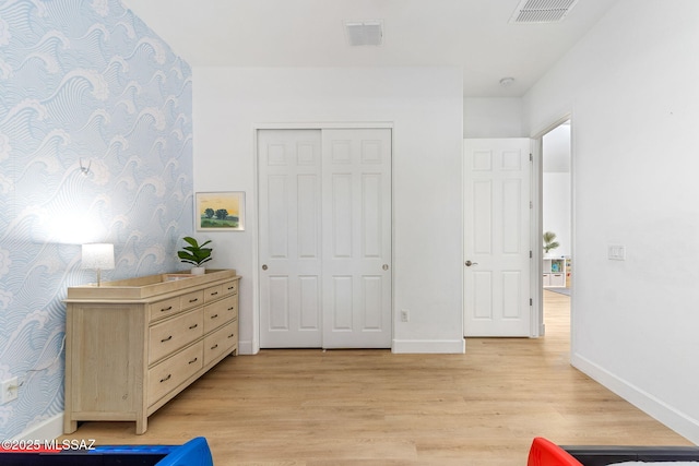bedroom with light wood-style flooring, visible vents, and baseboards