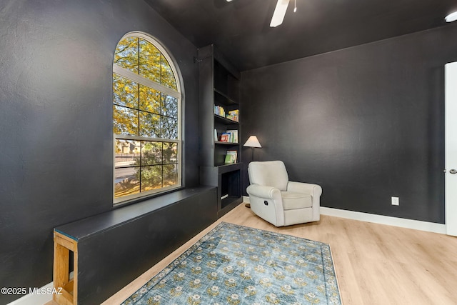 living area featuring plenty of natural light, wood finished floors, and ceiling fan
