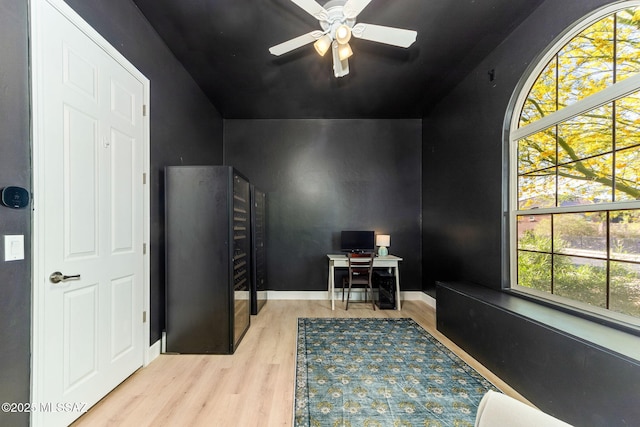 office area with a ceiling fan, wood finished floors, and vaulted ceiling