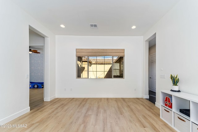 unfurnished living room featuring baseboards, visible vents, and light wood-style floors