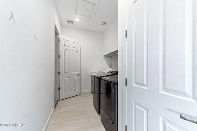 washroom featuring laundry area, visible vents, washing machine and clothes dryer, baseboards, and attic access