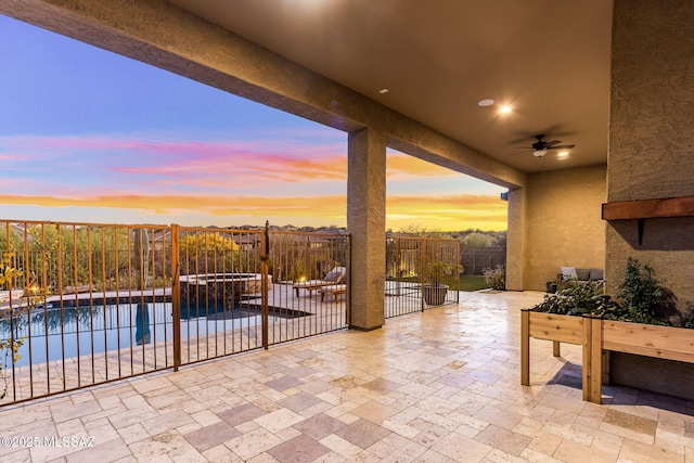 view of patio featuring fence, a ceiling fan, and a pool with connected hot tub