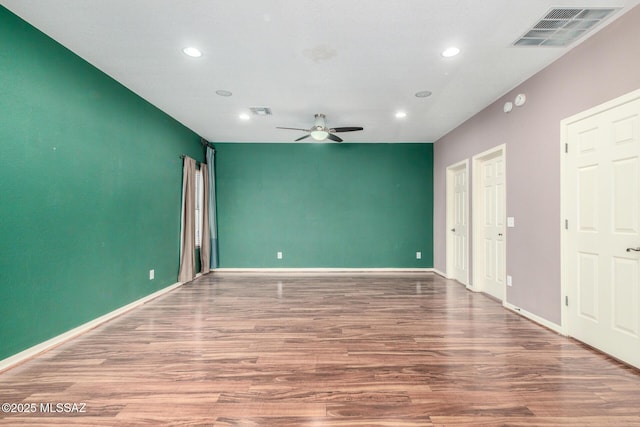 empty room featuring recessed lighting, visible vents, a ceiling fan, and wood finished floors