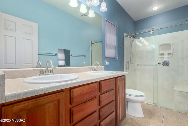 full bath featuring toilet, a stall shower, a sink, and tile patterned floors