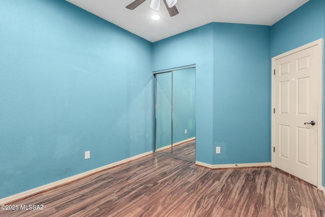 unfurnished bedroom featuring a closet, ceiling fan, baseboards, and wood finished floors