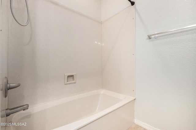 bathroom featuring baseboards and shower / washtub combination