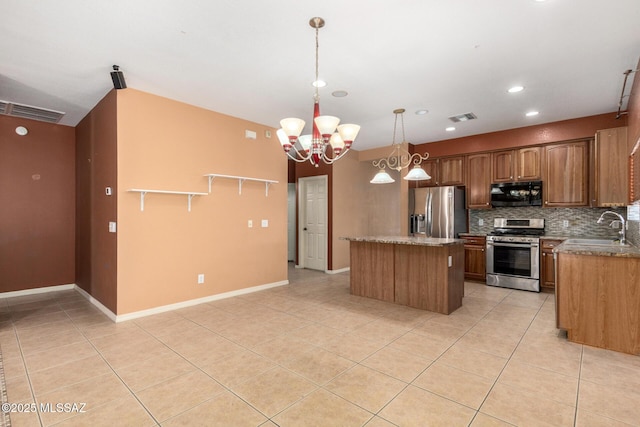 kitchen featuring visible vents, a sink, stainless steel appliances, decorative backsplash, and a kitchen island