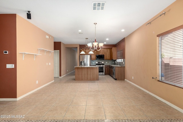 kitchen featuring tasteful backsplash, visible vents, a sink, stainless steel appliances, and a notable chandelier