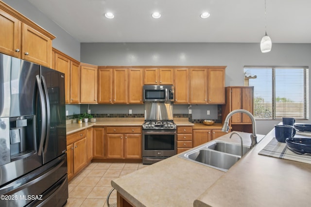 kitchen with a sink, light tile patterned flooring, recessed lighting, light countertops, and appliances with stainless steel finishes
