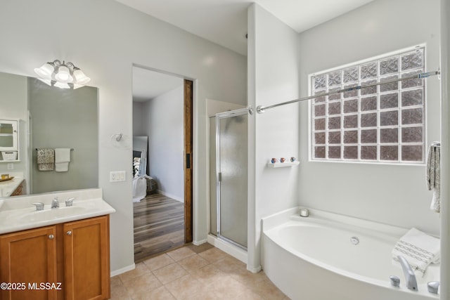 bathroom featuring a bath, vanity, a stall shower, and ensuite bathroom
