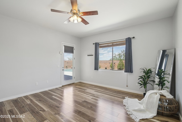 spare room featuring ceiling fan, wood finished floors, and baseboards