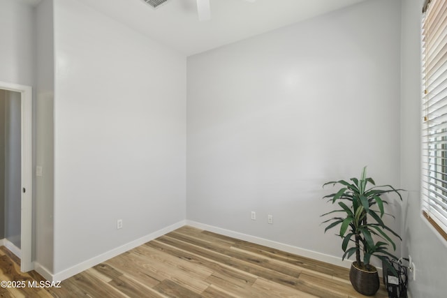 unfurnished room featuring ceiling fan, wood finished floors, and baseboards